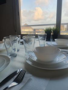 瓦伦西亚Apartamento Rio Turia的一张带盘子和玻璃杯的白色桌子