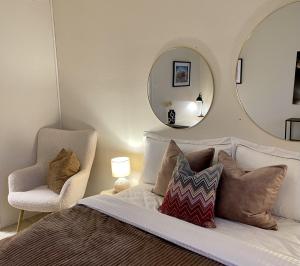 奥勒松A11的一间卧室配有一张带镜子和椅子的床