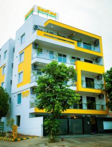 古尔冈Lime Tree Luxury Studio - Service Apartment Near Artemis Hospital ,Gurgaon的前面有棵树的建筑