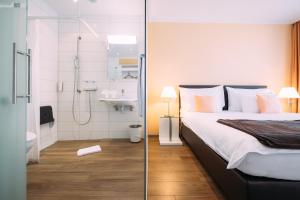 图恩楚真施特菲斯堡酒店的带淋浴和床的卧室以及浴室。
