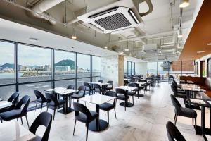 釜山Shiftdoor Residence Hari的用餐室设有桌椅和窗户。