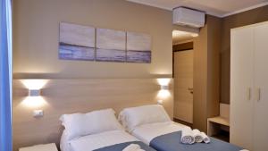 因佩里亚Pianomare Riviera Apartments and Rooms的一间卧室配有床和两个白色枕头