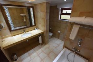 坎帕拉Casa Solada Hotel的一间带水槽、镜子和卫生间的浴室