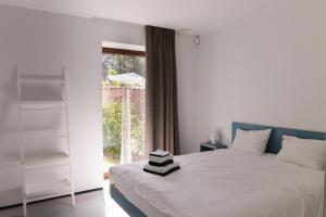 根特HUIS19 Luxury apartments的卧室配有白色的床和窗户。