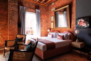 开普敦Old Foundry Hotel的一间卧室设有一张床和砖墙