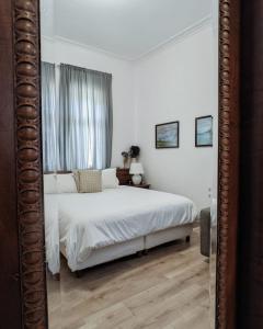 波格拉德茨Garden Villa Boutique Hotel的卧室配有白色的床和镜子