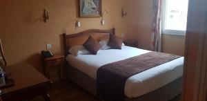Ligny-le-ChâtelLOGIS HOTEL - Le Relais Saint Vincent的酒店客房配有带白色床单和枕头的床。