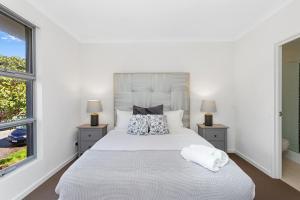 珀斯134 North Perth Nest For 4 Parking的一间卧室配有一张带两盏灯的大型白色床。