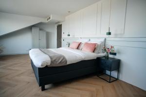 斯滕韦克MyHotel Steenwijk - Giethoorn的卧室配有一张带粉红色枕头的大床