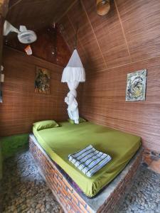 武吉拉旺Lucky Bamboo' Bungalows-Resto and OrangUtan Jungle Trekking Tours的一间房间,床上有灯