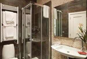 维戈普埃塔甘博亚酒店的一间带玻璃淋浴和水槽的浴室