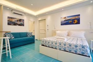 阿纳卡普里ilTrucioloBBSuite的一间卧室配有一张床和一张蓝色的沙发