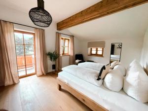 克罗伊特Lichtdurchflutete Doppelhaushälfte in Kreuth的卧室配有白色大床和白色枕头