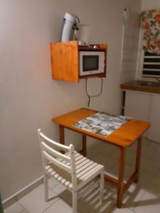 Petit-CanalARCHE DE L'ISLE的一张带微波炉的小桌子和一张白色椅子
