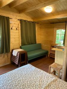 阿尔巴AlbaVillage Hotel & Camping Wellness的小屋内带床和长凳的房间