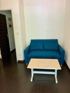 吕兹-圣索沃尔MS APPART** 5 PERS BALCON PISCINE LUZ 5MN的一张蓝色的沙发,位于一个咖啡桌的房间