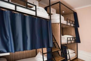 波尔图Rosalma Hostel的双层床间 - 带蓝色的浴帘