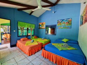 托尔图格罗Cabinas Tortuguero Natural的蓝色墙壁客房的两张床
