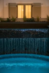 梅萨雷亚AVAL All Suite Hotel的一座大楼前带瀑布的游泳池
