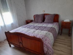Celles-sur-BelleCHEZ VIVIANE的一间卧室配有一张大床和紫色棉被