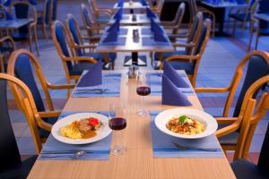 托波尔希卡托波尔希卡温泉-威斯纳酒店的一张长桌,有两盘食物和酒杯