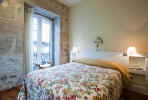 维戈普埃塔甘博亚酒店的一间卧室配有一张带花卉床罩的床和窗户。