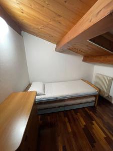 法诺Casa Della Valle的木制天花板的客房内的一张小床