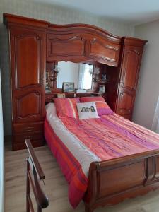 Celles-sur-BelleCHEZ VIVIANE的一间卧室配有一张木制大床,配有木架