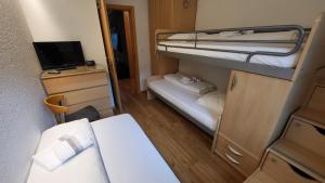 WilerApartment Di Lembah的小房间设有两张双层床和电视