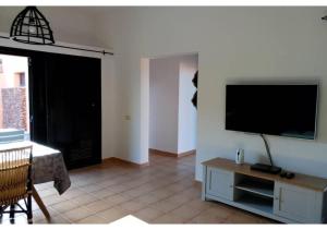 拉奥利瓦Anahi Homes Corralejo - Villa Codeso 1的客厅设有壁挂式平面电视。