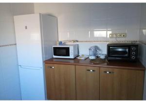 拉奥利瓦Anahi Homes Corralejo - Villa Codeso 1的厨房配有微波炉和冰箱。