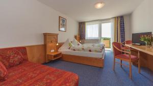 腓特烈港Gasthof Krone Hotel & Restaurant的配有一张床和一张书桌的酒店客房