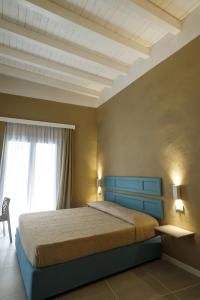 特拉帕尼Palazzo Mancina的一间卧室配有一张带蓝色床头板的床和窗户