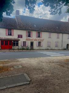 La Guerche-sur-lʼAuboisHôtel du Cerf的街上有红色门的白色建筑