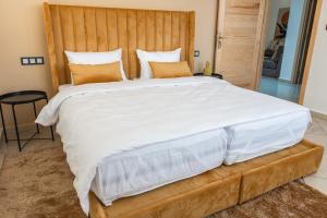 达赫拉Résidence Amal的卧室内的一张带木制床头板的大床