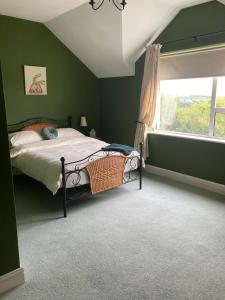 基利贝格斯Millfarm House的一间卧室设有绿色的墙壁和一张带窗户的床