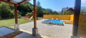 帕莱VIKENDICA SA BAZENOM NOLE Jahorina的后院设有游泳池和游乐场
