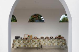 普罗奇达La Casa sul Faro的白色的客房设有三扇窗户,配有一张桌子