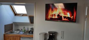 比尔弗登Tinyloft的厨房设有挂在墙上的壁炉