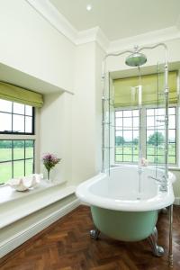 Bronllys朗格伊德大厅酒店的白色的浴室设有浴缸和窗户。