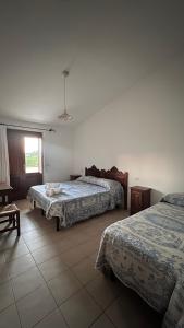 萨穆盖奥Agriturismo da Lino AGRIPIZZA的酒店客房设有两张床和窗户。