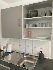 Maison calme et confortable的厨房配有水槽和白色橱柜