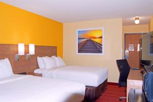 马凯特Days Inn by Wyndham Marquette的酒店客房设有两张床和电视。