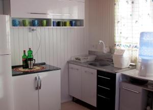 乌鲁比西Casa de Ferias Alternativa的厨房配有白色橱柜和2瓶台面