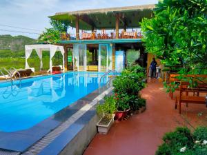 宁平Tam Coc Wonderland Bungalow的一个带游泳池和房子的度假胜地
