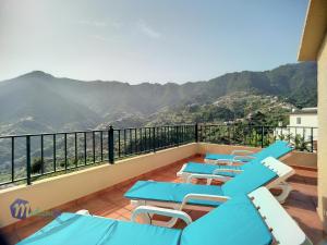 克鲁什港Casa do Romaninho的阳台配有蓝色桌椅,享有山景。
