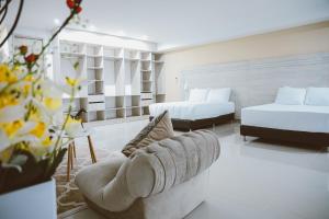巴兰卡韦梅哈Hotel Súper Estrellas的一间带两张床和一张沙发的客厅