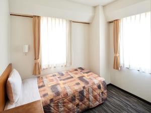 东京赤阪玛璐轩酒店的一间卧室设有一张床和两个窗户。