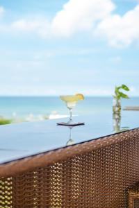 San NarcisoThe Palms Resort & Bar的玻璃杯,坐在俯瞰大海的阳台上