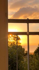 SkovbyBakkehuset Countryhouse的透过窗户欣赏日落美景